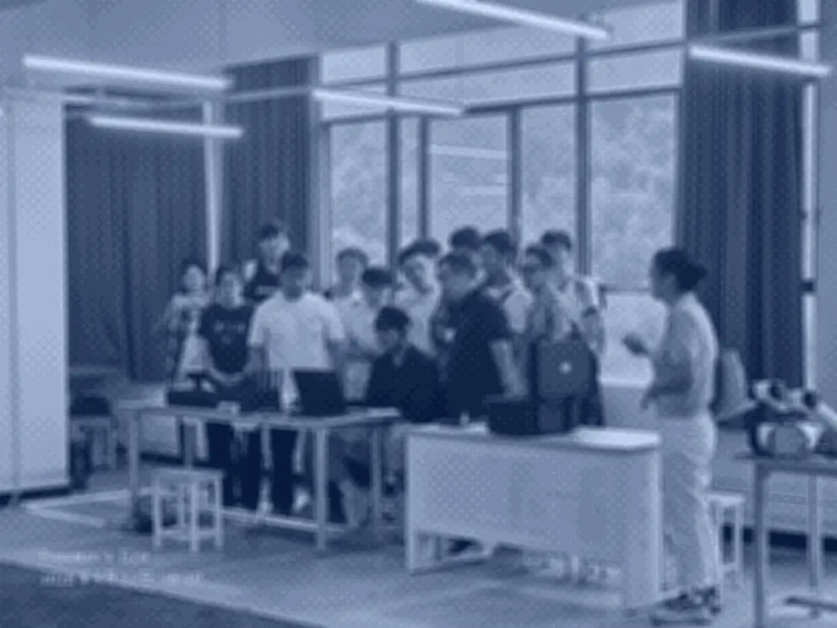 实训室内成员围桌，一人讲解