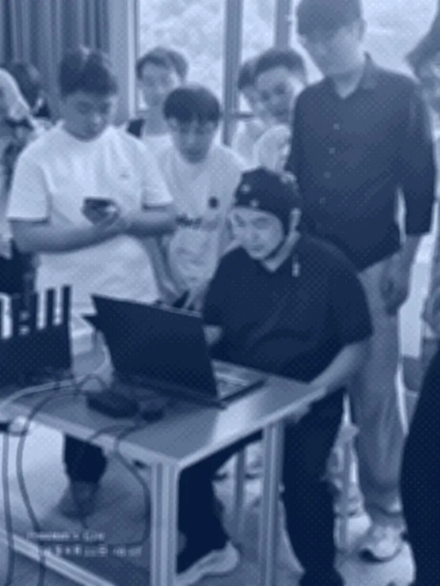 成员佩戴脑电电极帽面向笔记本电脑，桌上有带天线的采集设备与线缆